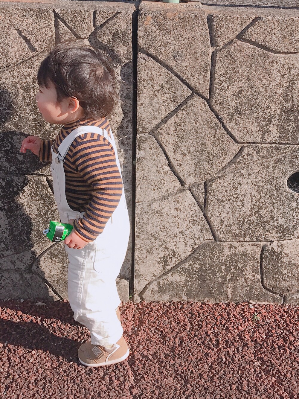 ホワイト系のサロペット/オーバーオール、ブラウン系のニット/セーター、ブラウン系のスニーカーを着用したキッズの秋コーディネートの1枚目の写真