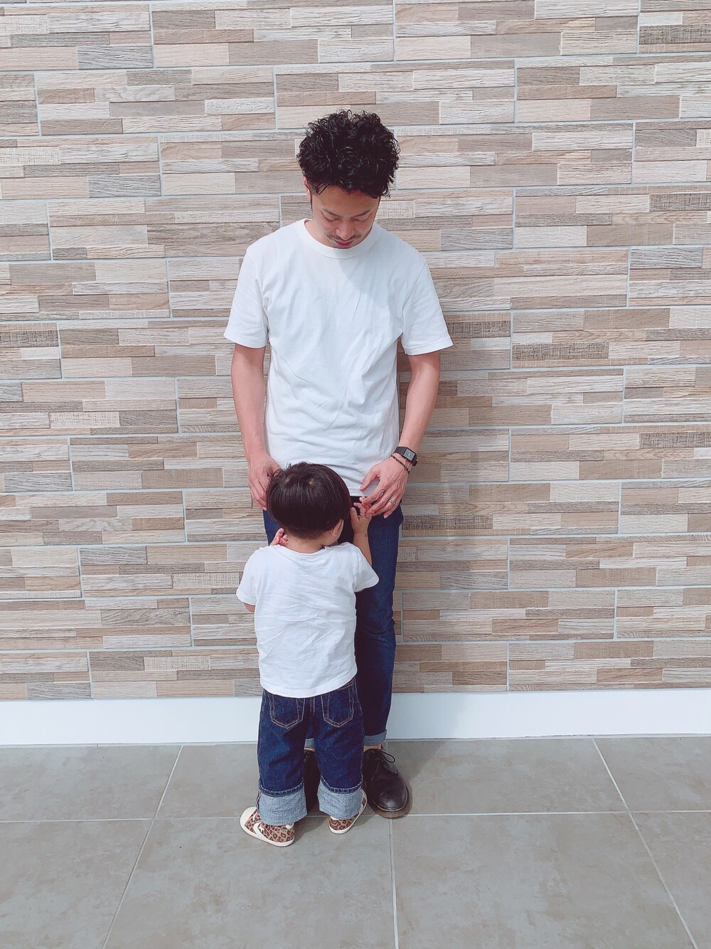 ホワイト系のTシャツ/カットソー、ブルー系のデニムパンツ、ブラック系のシューズを着用したキッズの冬コーディネートの1枚目の写真