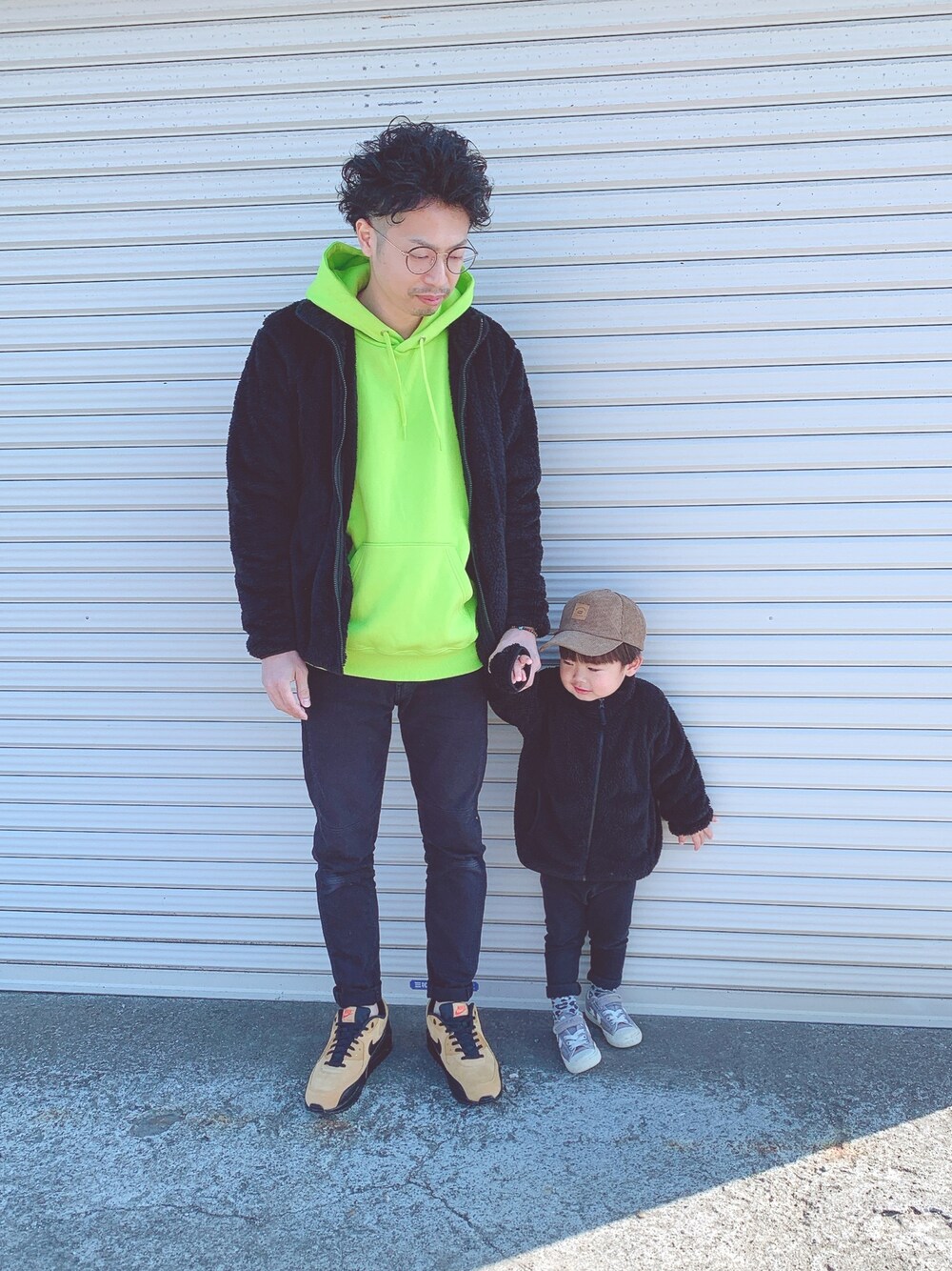 グリーン系のパーカー、ブラック系のその他アウター、ブラック系のパンツを着用したキッズの冬コーディネートの1枚目の写真