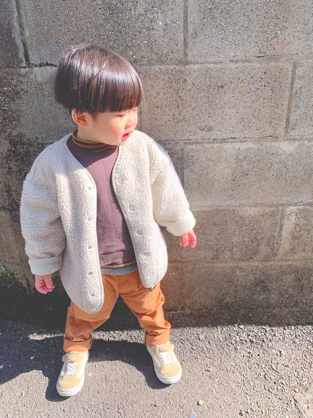 ホワイト系のジャケット/アウター、ブラウン系のスウェット、ブラウン系のニット/セーターを着用したキッズの冬コーディネートの1枚目の写真