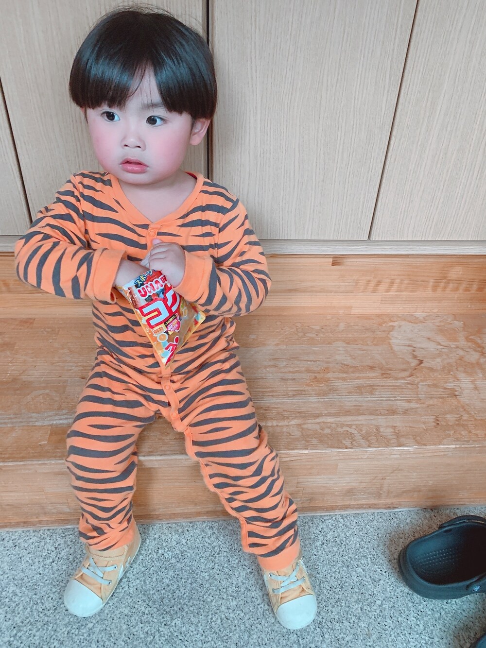 オレンジ系のオールインワン・サロペット、イエロー系のスニーカー、ベージュ系のその他を着用したキッズの春コーディネートの1枚目の写真