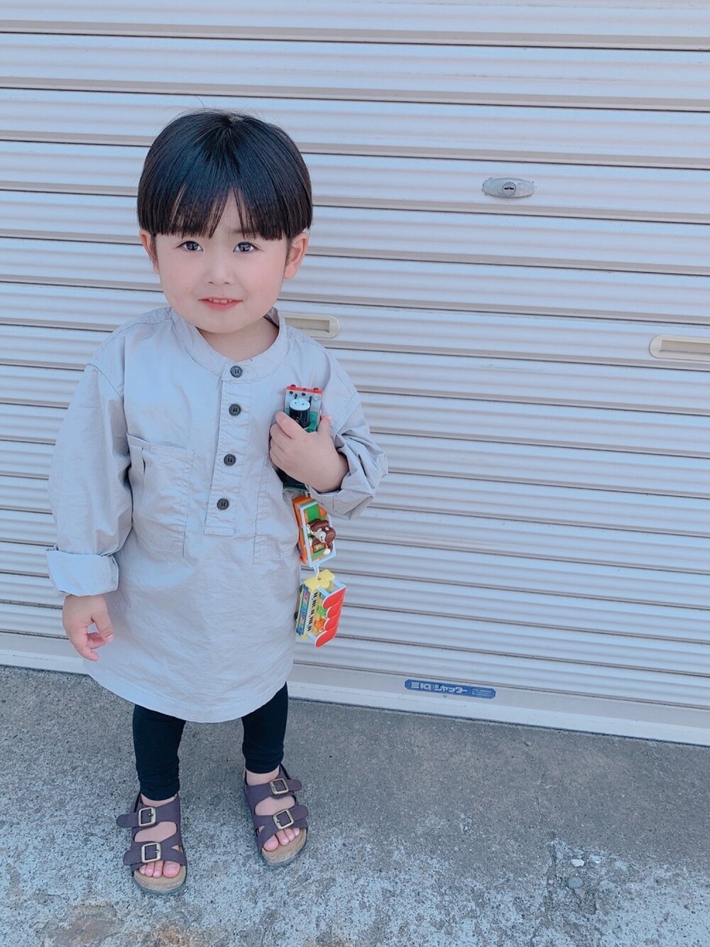 グレー系のシャツ/ブラウス、ブラウン系のサンダル、ブラック系のレギンス/スパッツを着用したキッズの春コーディネートの1枚目の写真