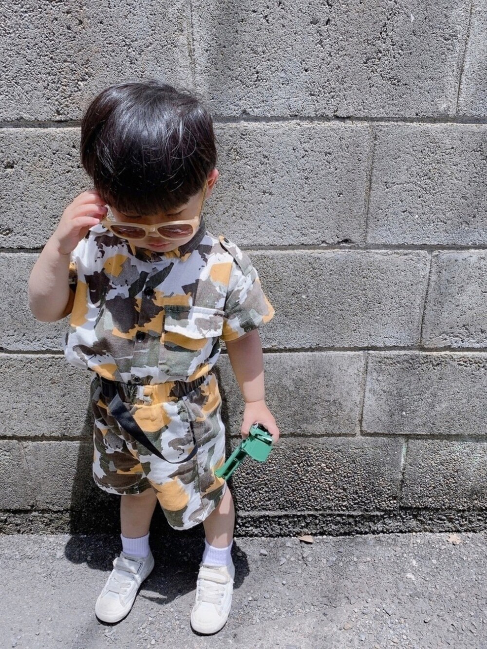 イエロー系のシャツ/ブラウス、ホワイト系のスニーカー、イエロー系のサングラスを着用したキッズの春コーディネートの1枚目の写真