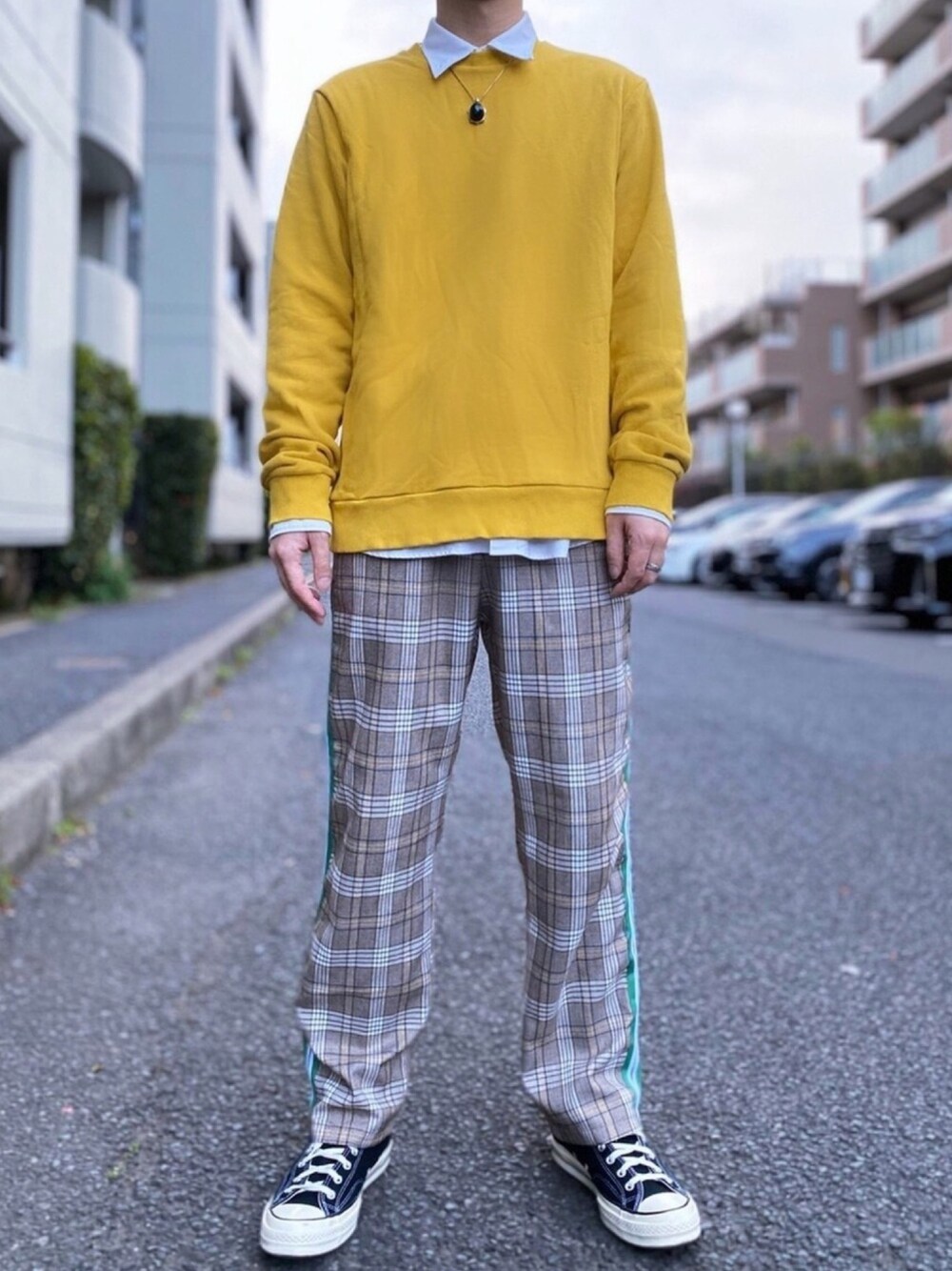 イエロー系のスウェット、ブラック系のスニーカー、ベージュ系のパンツを着用したメンズの春コーディネートの1枚目の写真