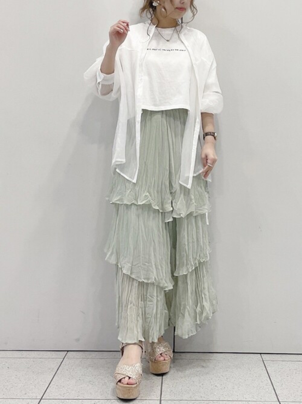 ホワイト系のシャツ/ブラウス、グリーン系のスカート、ホワイト系のTシャツ/カットソーを着用したレディースの春コーディネートの1枚目の写真