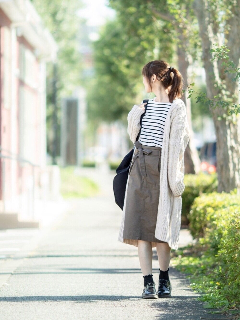 ホワイト系のTシャツ/カットソー、グリーン系のスカート、ホワイト系のカーディガン/ボレロを着用したレディースの秋コーディネートの1枚目の写真