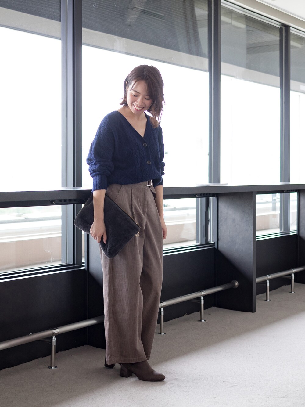 ブルー系のカーディガン/ボレロ、イエロー系のその他パンツ、グレー系のクラッチバッグを着用したレディースの秋コーディネートの1枚目の写真