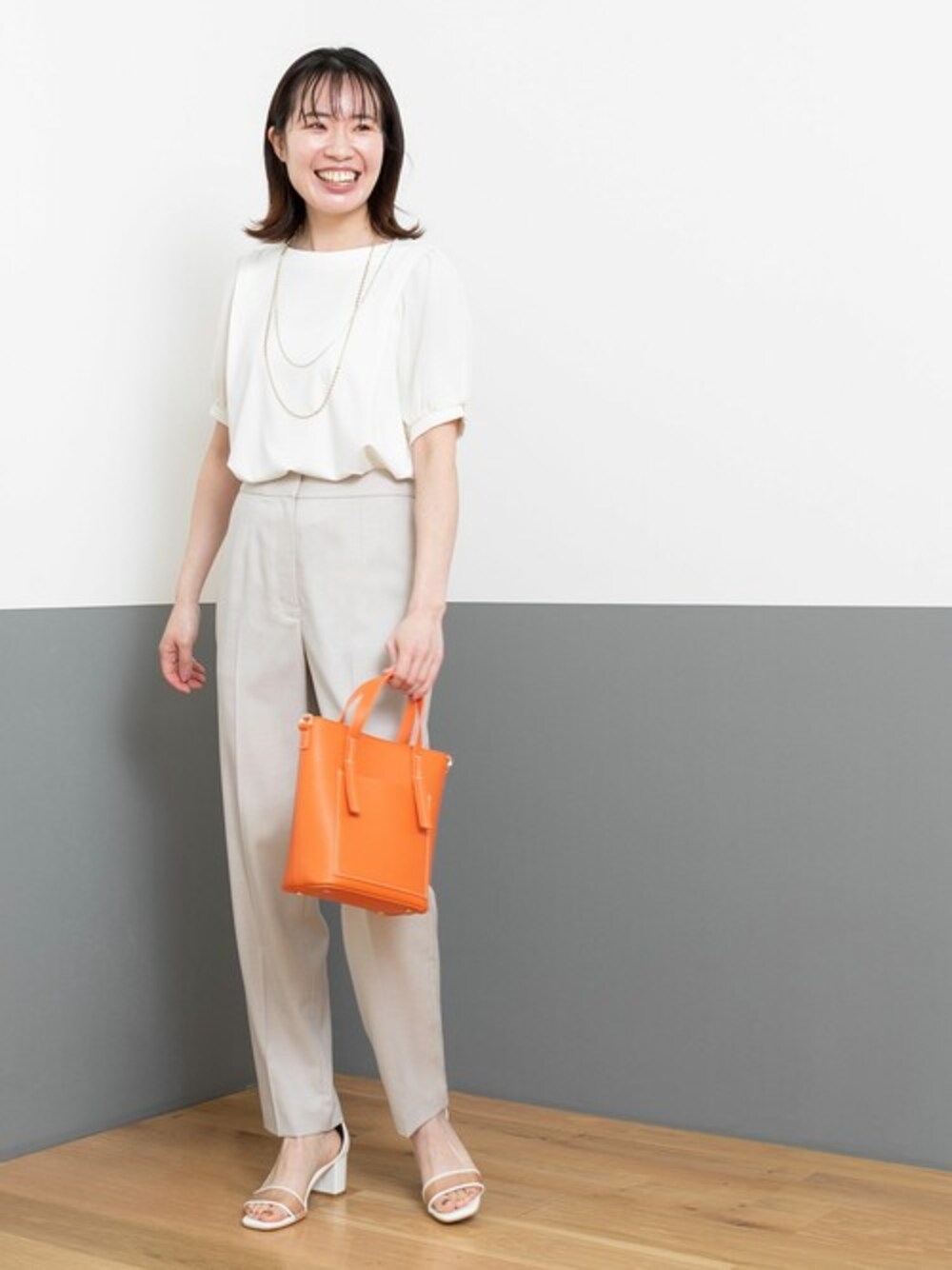 ホワイト系のTシャツ/カットソー、ベージュ系のその他パンツ、オレンジ系のトートバッグを着用したレディースの春コーディネートの1枚目の写真