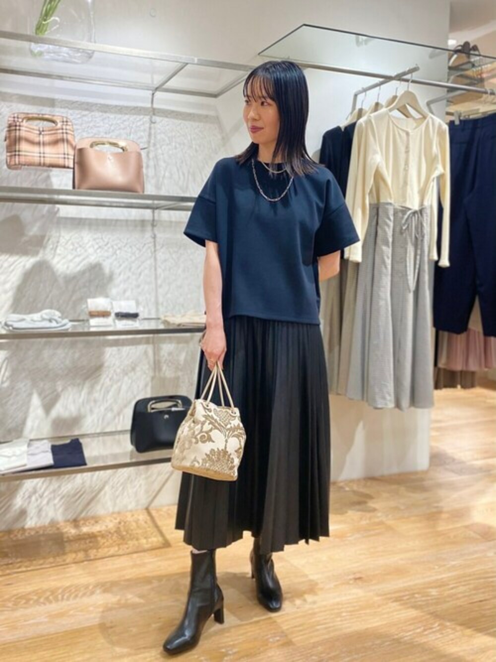 ブラック系のTシャツ/カットソー、ブラック系のスカート、ブラック系のブーツを着用したレディースの夏コーディネートの1枚目の写真