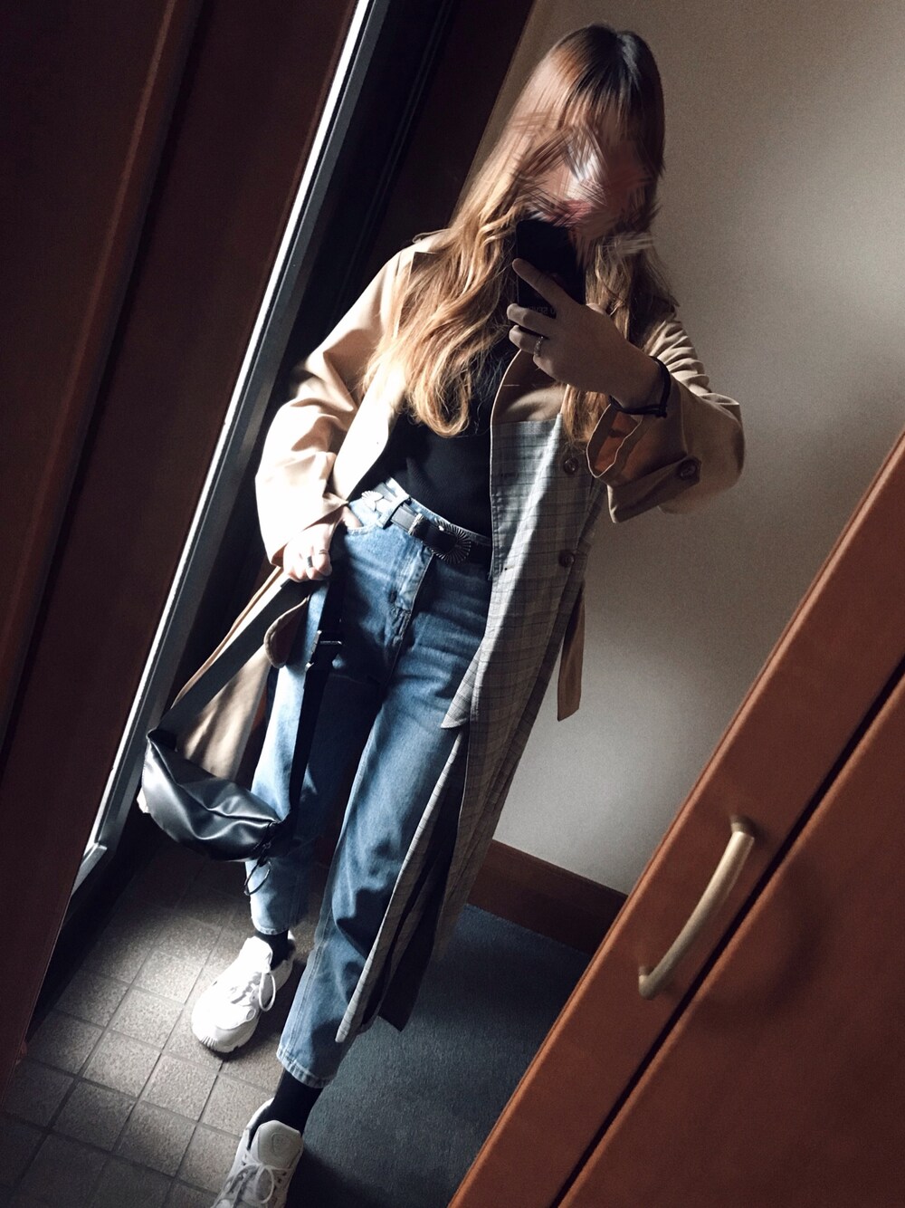 ブルー系のデニムパンツ、ホワイト系のスニーカー、ブラック系のボディバッグ/ウエストポーチを着用したレディースの秋コーディネートの1枚目の写真