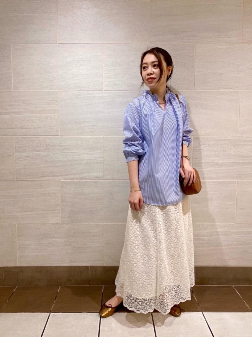 ゴールド系のバレエシューズ、ホワイト系のスカート、イエロー系のショルダーバッグを着用したレディースの冬コーディネートの1枚目の写真