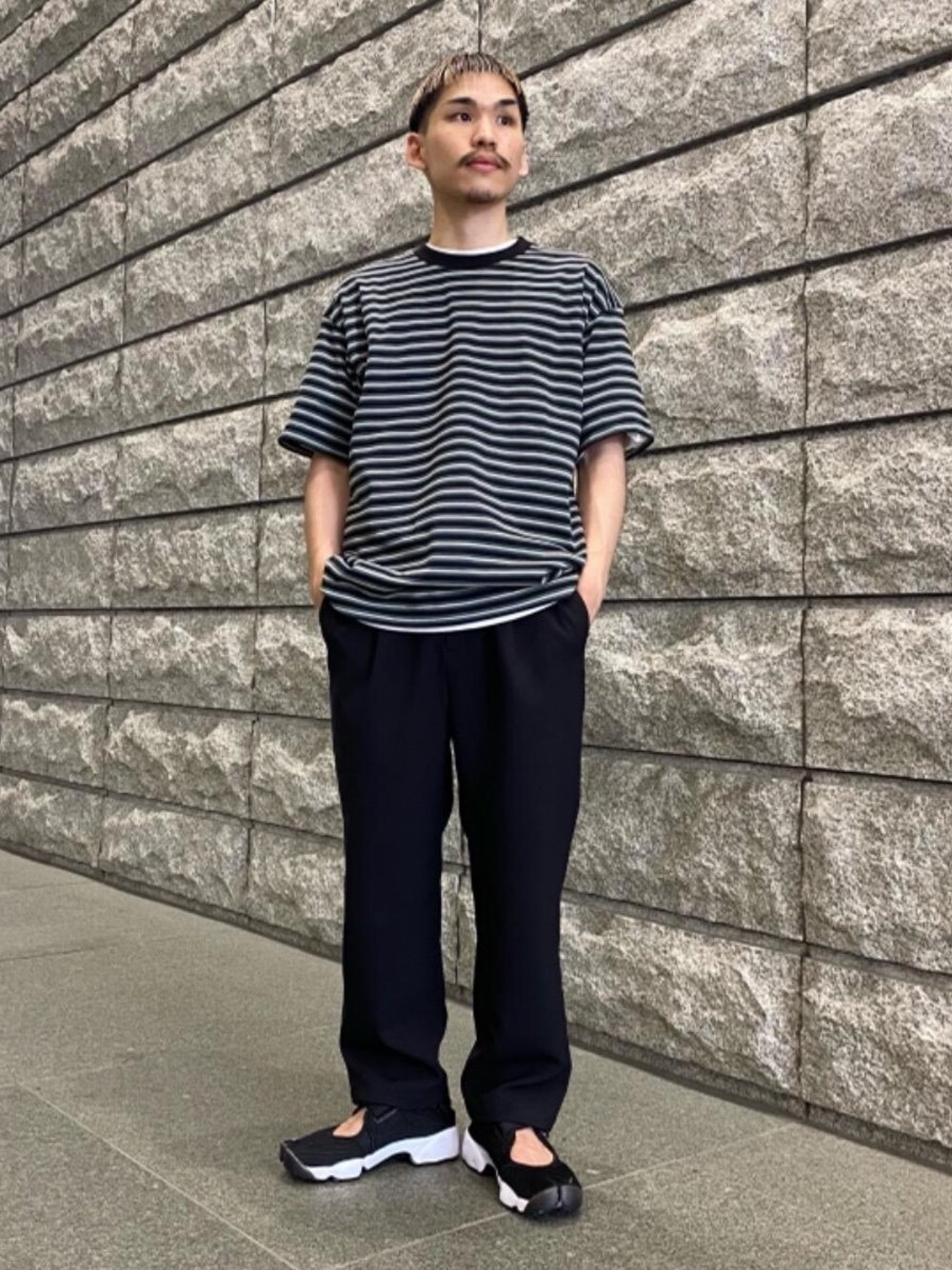 ブラック系のその他パンツ、ブラック系のTシャツ/カットソー、その他のスニーカーを着用したメンズの春コーディネートの1枚目の写真