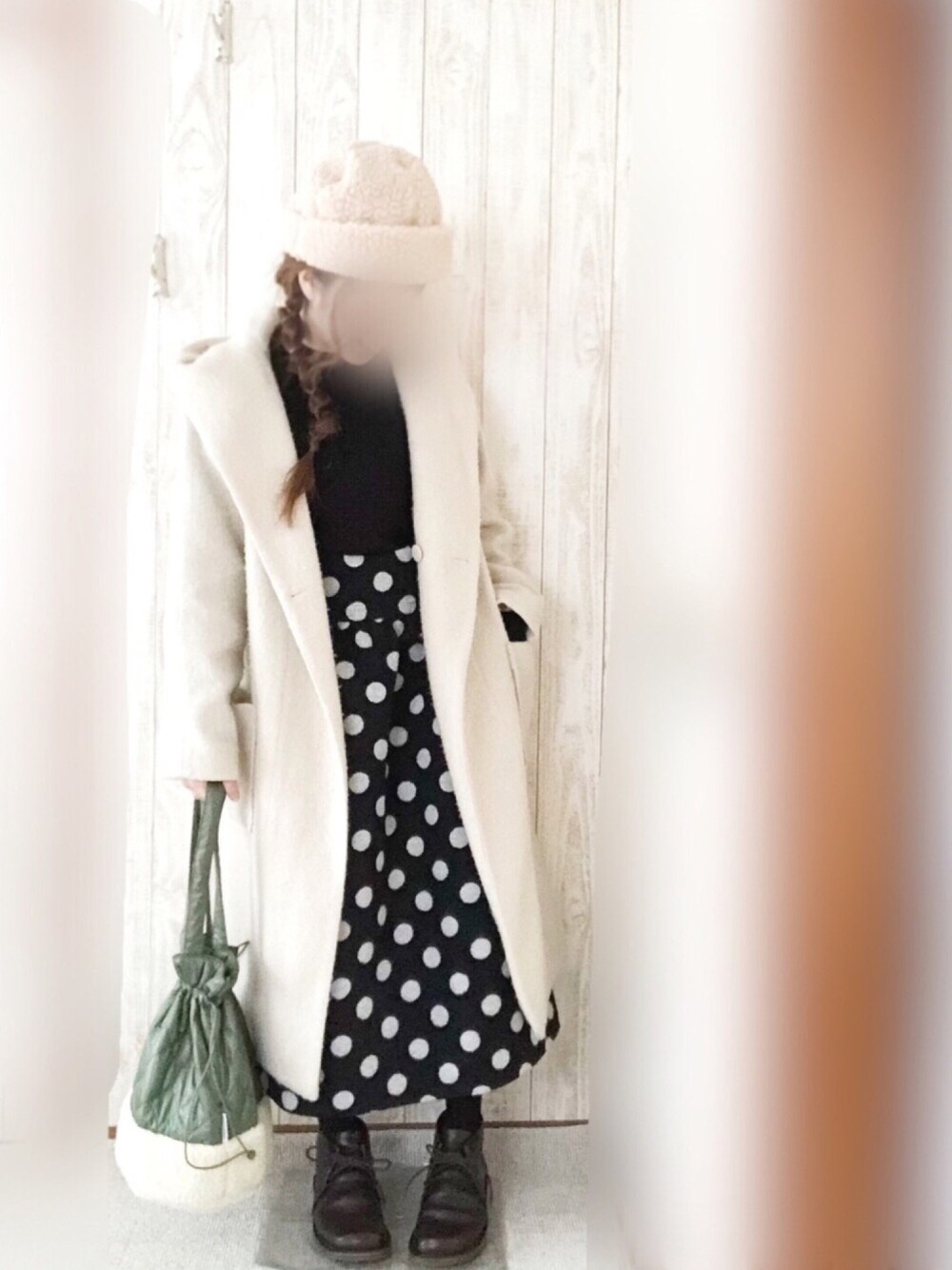 ブラウン系のシューズ、ブラック系のスカート、ホワイト系のジャケット/アウターを着用したレディースの冬コーディネートの1枚目の写真