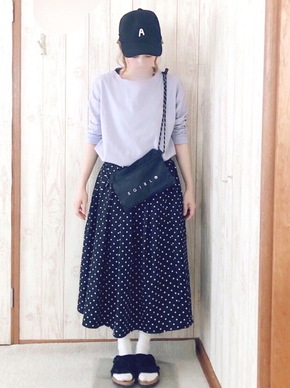 ブラック系のサンダル、パープル系のトップス、ブラック系のショルダーバッグを着用したレディースの春コーディネートの1枚目の写真