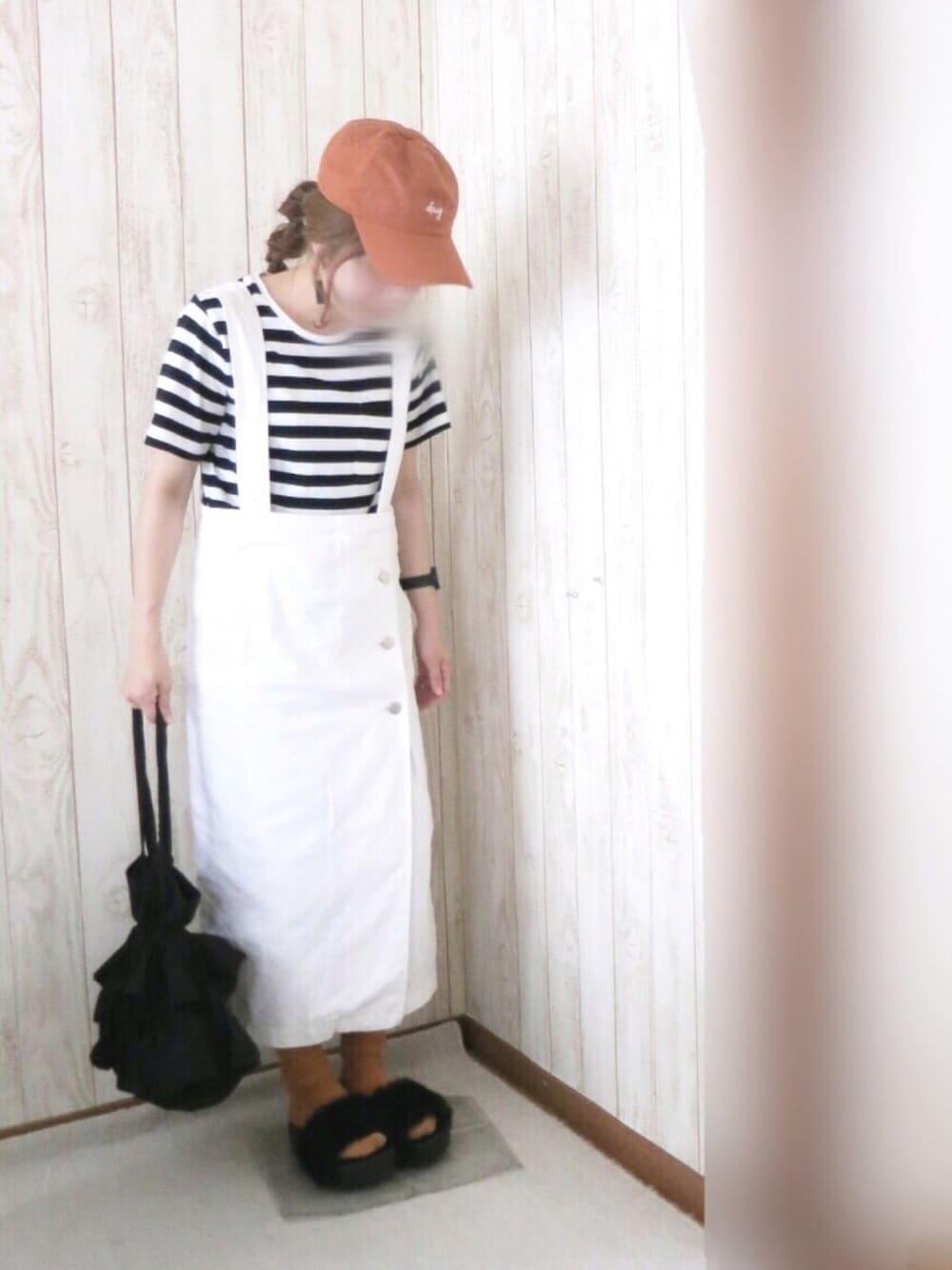 ブラック系のサンダル、ホワイト系のジャンパースカート、ブラック系のトートバッグを着用したレディースの夏コーディネートの1枚目の写真