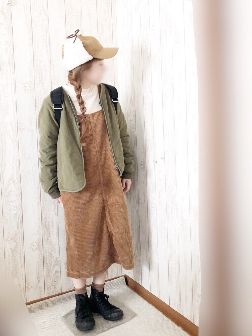 ブラック系のスニーカー、イエロー系のジャンパースカート、グリーン系のジャケット/アウターを着用したレディースの秋コーディネートの1枚目の写真