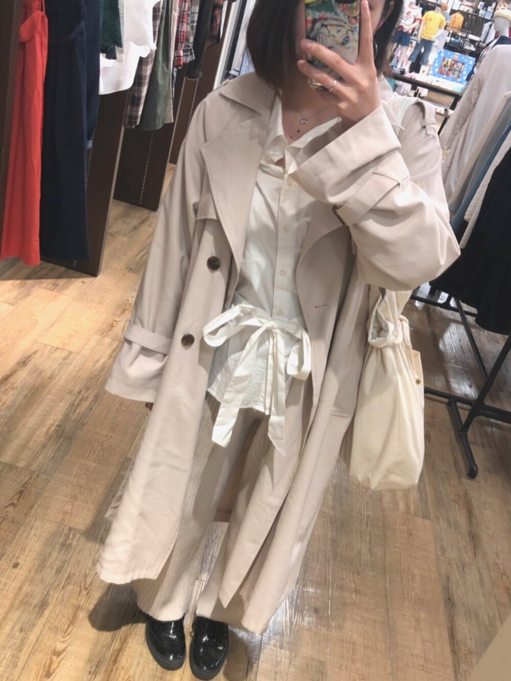 ベージュ系のその他パンツ、ブラック系のスニーカー、ホワイト系のトレンチコートを着用したレディースの春コーディネートの1枚目の写真