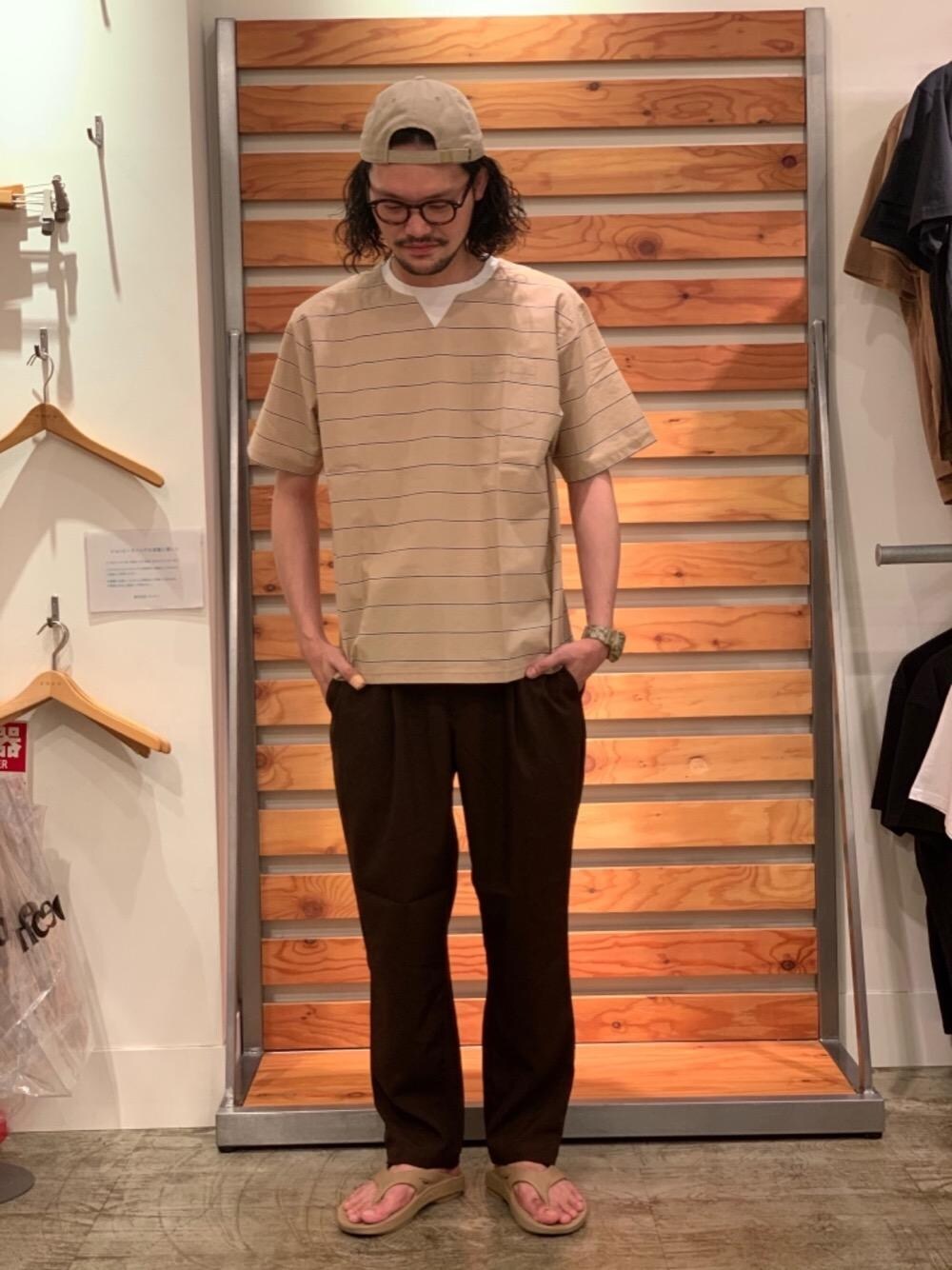 ベージュ系のTシャツ/カットソー、ブラウン系のその他パンツ、ベージュ系のキャップを着用したメンズの夏コーディネートの1枚目の写真