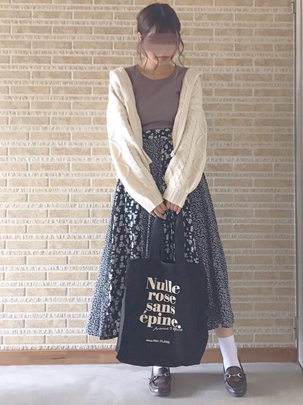 ホワイト系のパーカー、ブラック系のサロペット/オーバーオール、ブラック系のスカートを着用したレディースの秋コーディネートの1枚目の写真