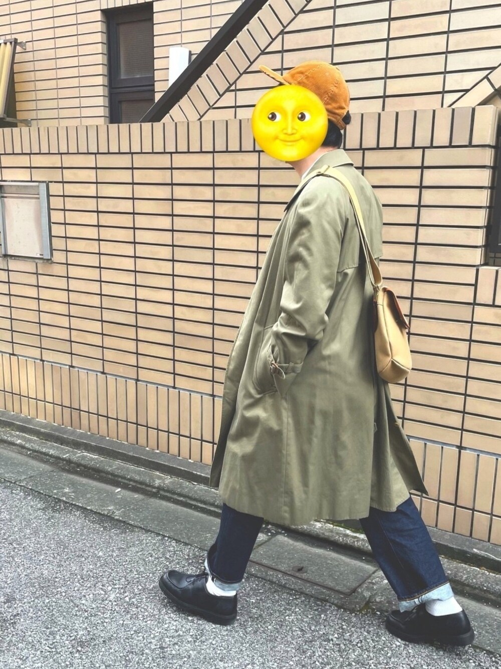 ベージュ系のショルダーバッグ、ブラック系のブーツ、ブルー系のデニムパンツを着用したメンズの春コーディネートの1枚目の写真