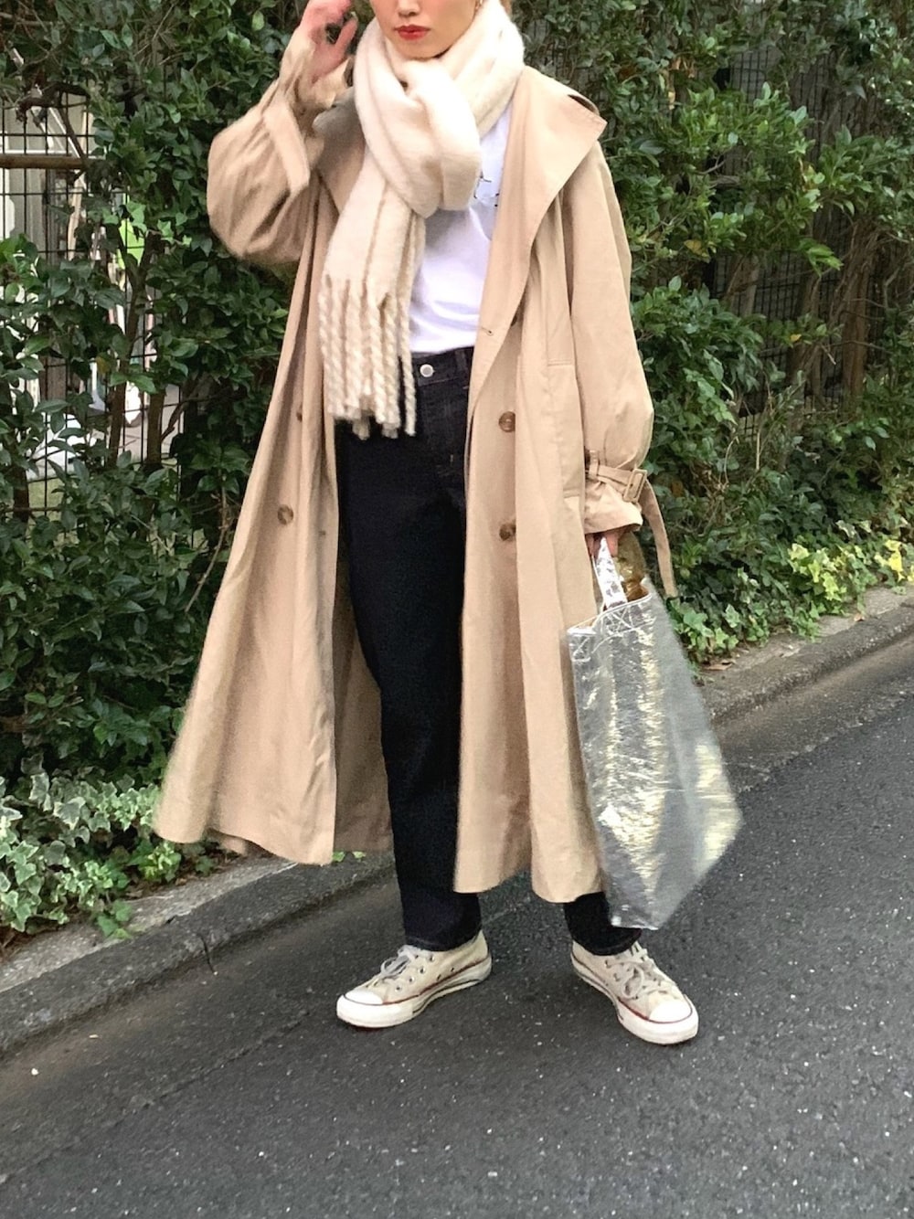 ブルー系のデニムパンツ、シルバー系のトートバッグ、ベージュ系のスニーカーを着用したレディースの秋コーディネートの1枚目の写真