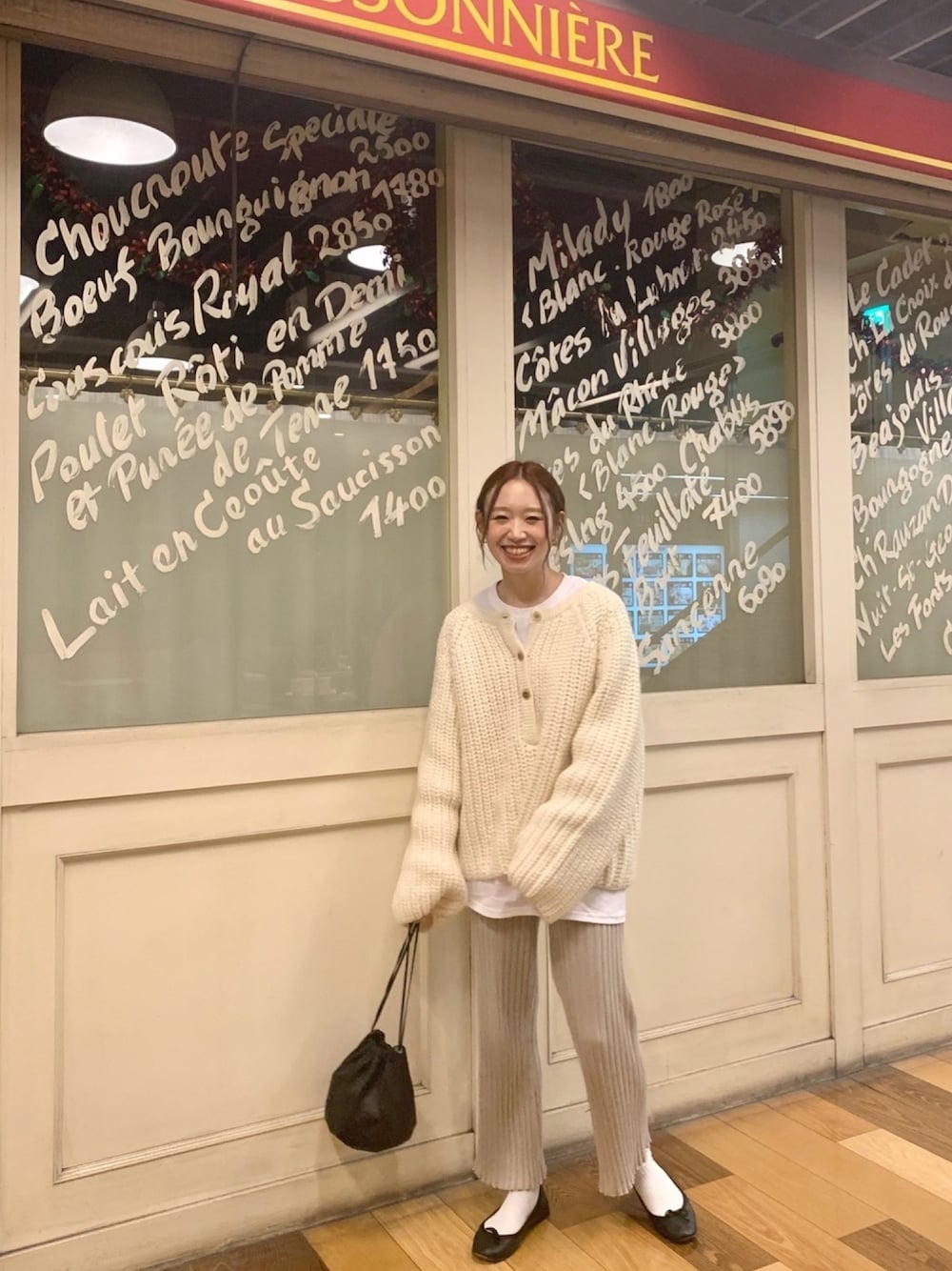 ホワイト系のニット/セーター、ブラック系のハンドバッグ、ブラック系のバレエシューズを着用したレディースの秋コーディネートの1枚目の写真