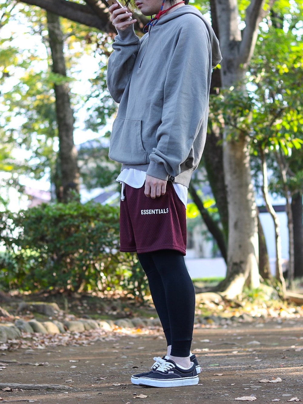 グリーン系のパーカー、ホワイト系のタンクトップ、レッド系のパンツを着用したメンズの秋コーディネートの1枚目の写真