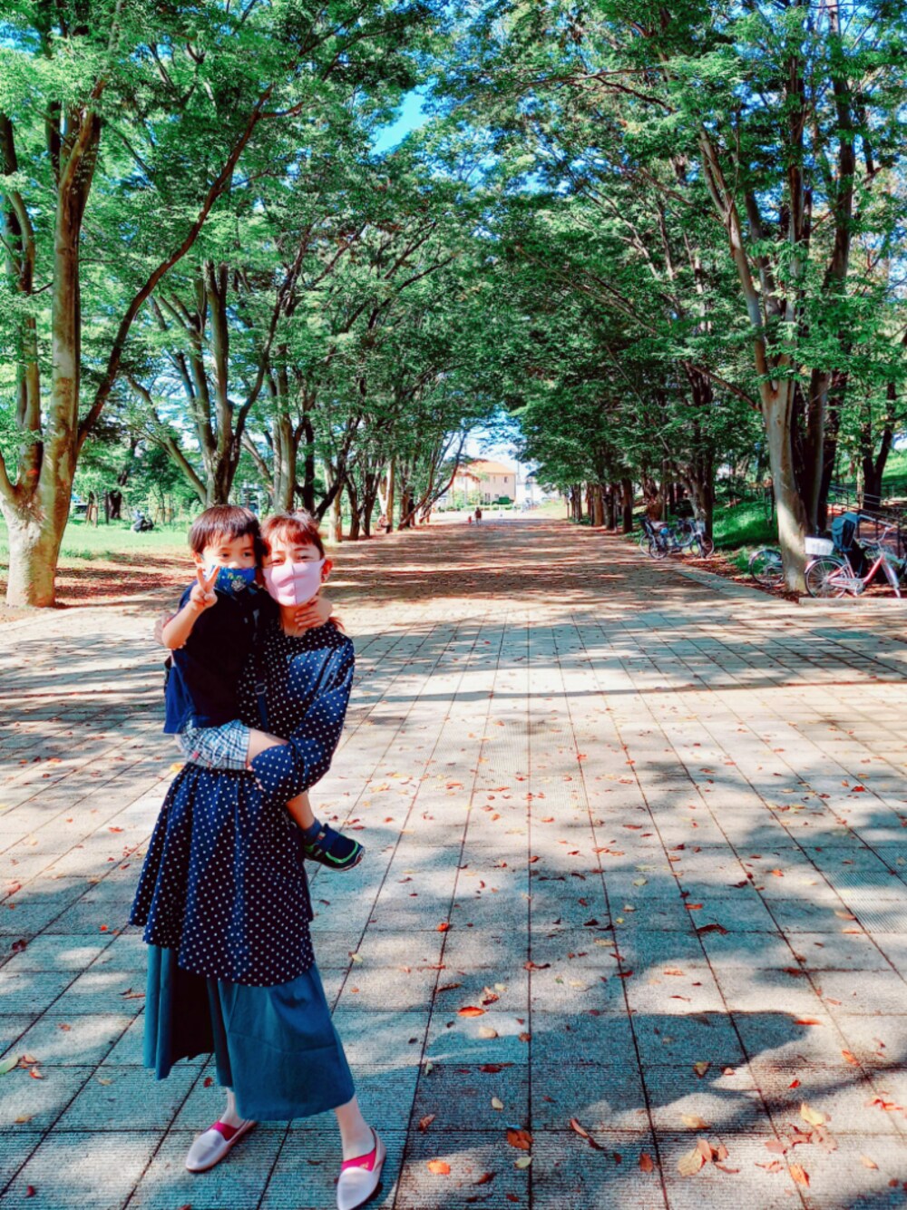 ゴールド系のスリッポン、グリーン系のワンピース、ブルー系のワンピースを着用したレディースの秋コーディネートの1枚目の写真