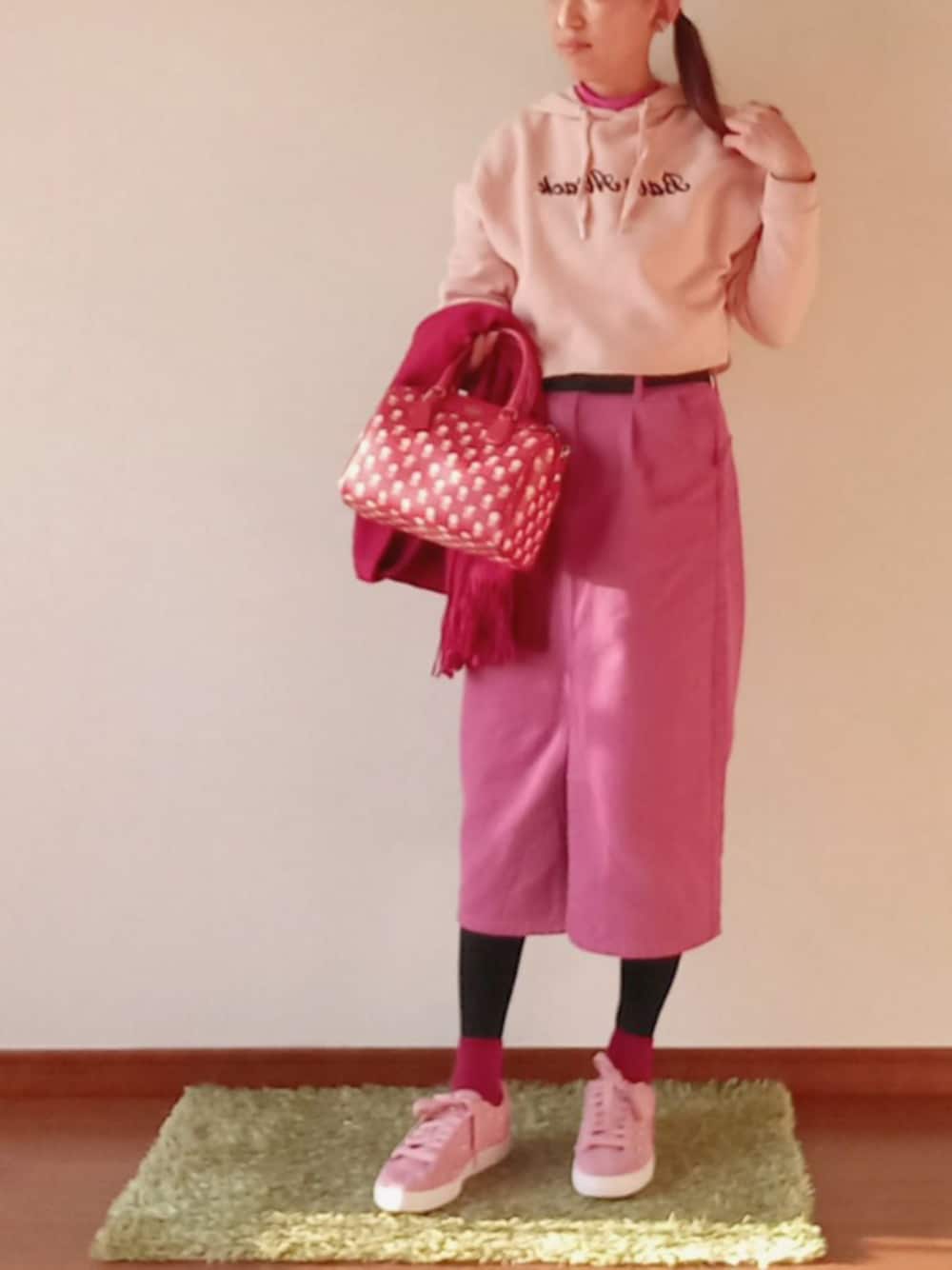 ピンク系のスカート、レッド系のショルダーバッグ、ピンク系のスニーカーを着用したレディースの冬コーディネートの1枚目の写真