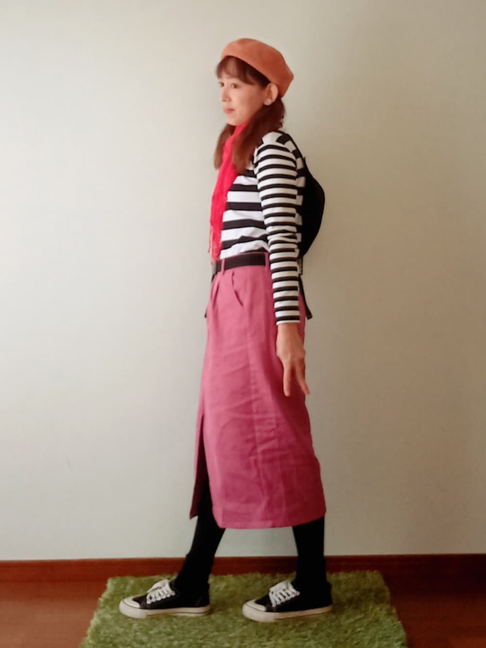 ピンク系のスカート、ホワイト系のトップス、ブラック系のスニーカーを着用したレディースの冬コーディネートの1枚目の写真