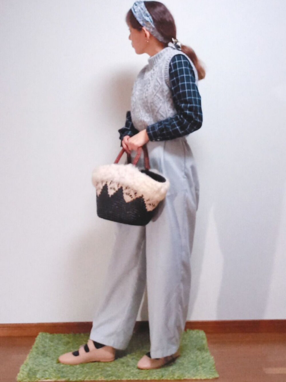 グレー系のニット/セーター、ベージュ系のバレエシューズ、ブルー系のかごバッグを着用したレディースの春コーディネートの1枚目の写真