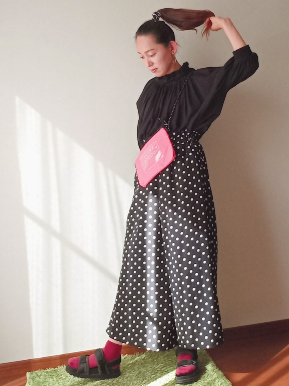 ピンク系のショルダーバッグ、ブラック系のオールインワン・サロペット、ブラック系のTシャツ/カットソーを着用したレディースの春コーディネートの1枚目の写真