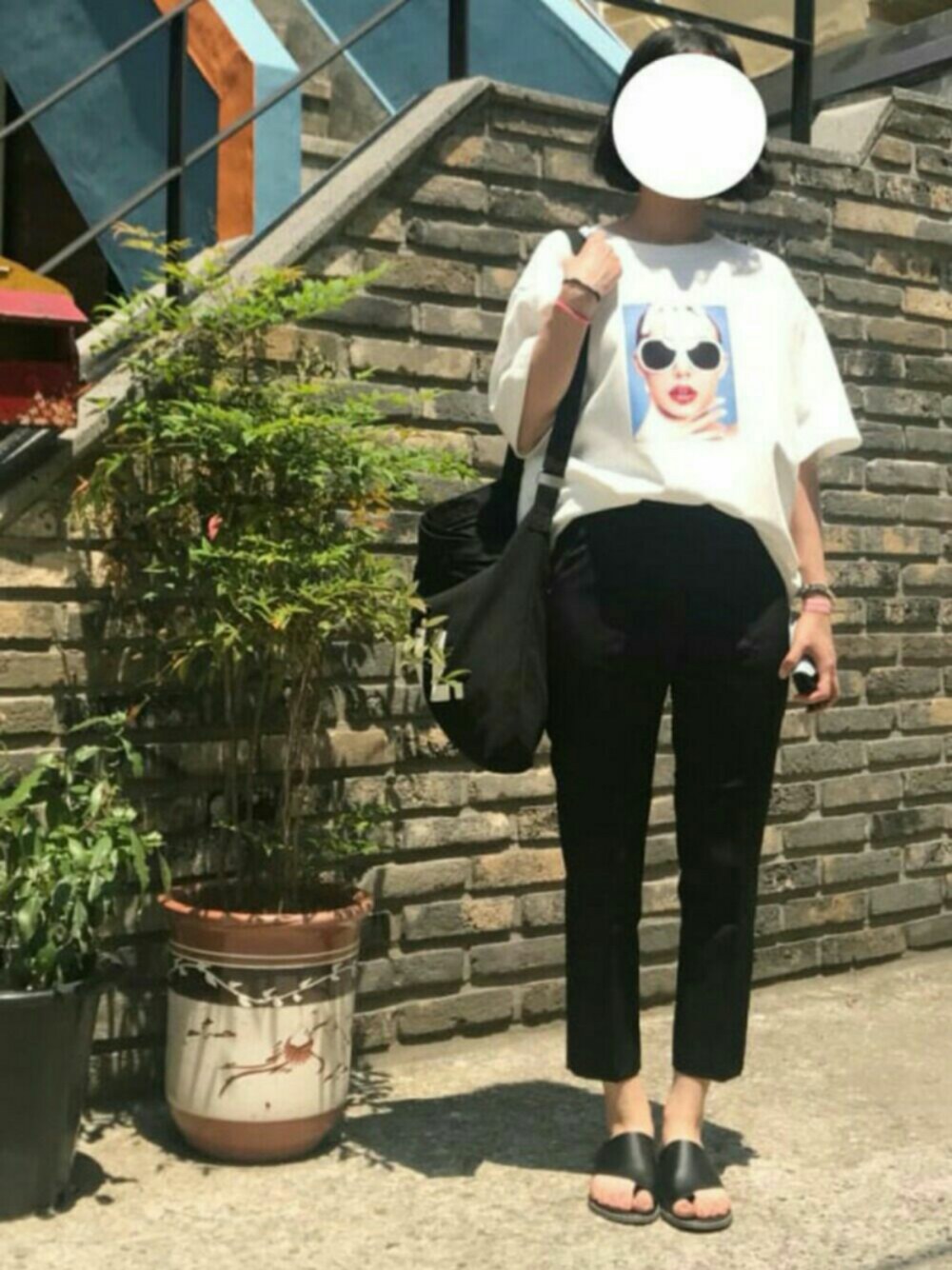 ホワイト系のTシャツ/カットソー、ブラック系のスラックス、ブラック系のサンダルを着用したレディースの春コーディネートの1枚目の写真