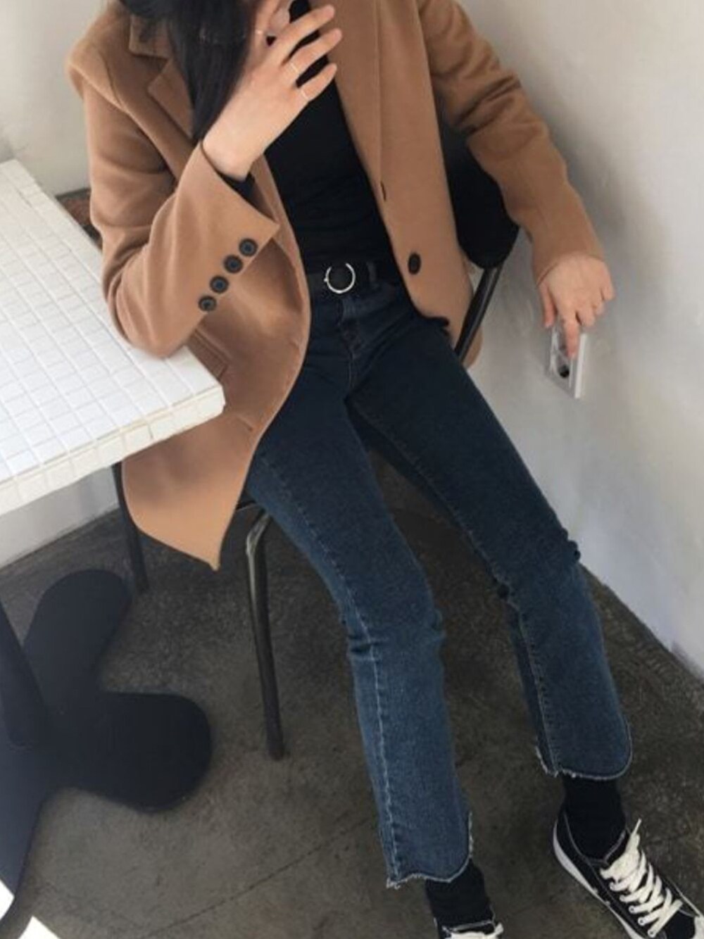 ブルー系のデニムパンツ、ベージュ系のチェスターコートを着用したレディースの秋コーディネートの1枚目の写真