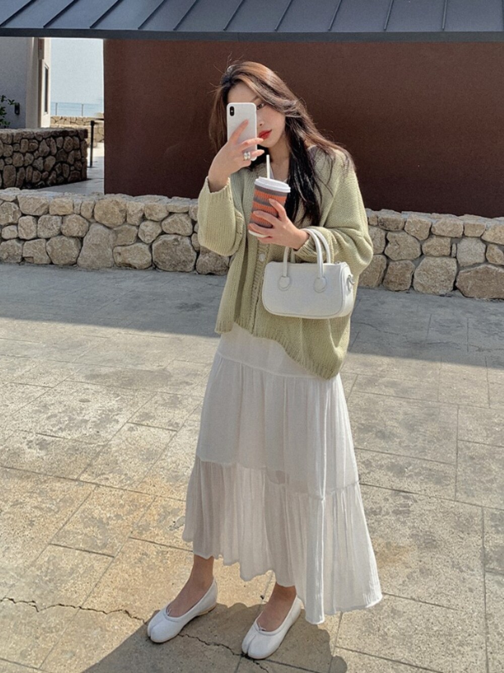 グリーン系のカーディガン/ボレロを着用したレディースの春コーディネートの1枚目の写真