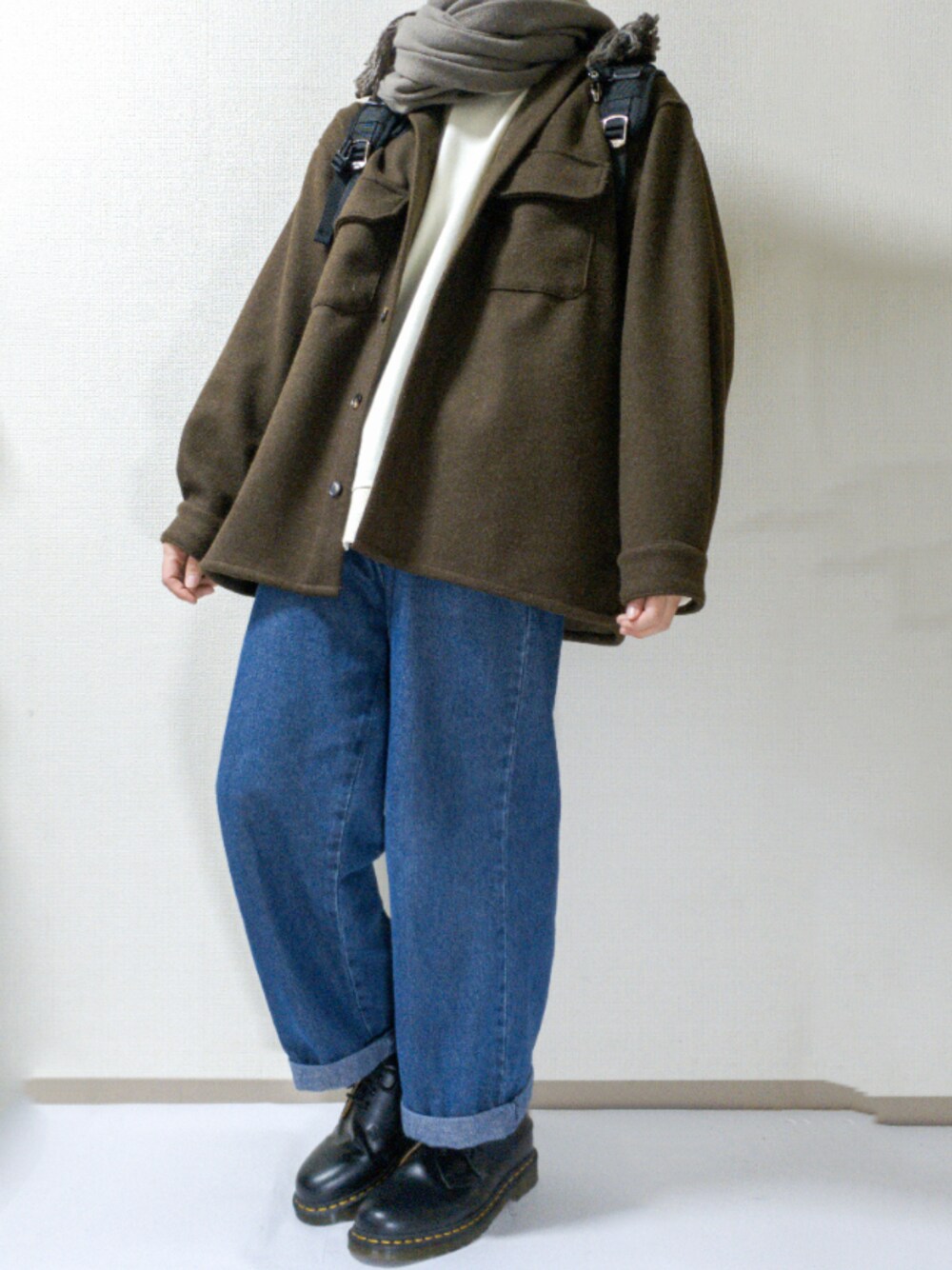 ホワイト系のスウェット、ブラウン系のシャツ/ブラウス、ブルー系のデニムパンツを着用したメンズの冬コーディネートの1枚目の写真