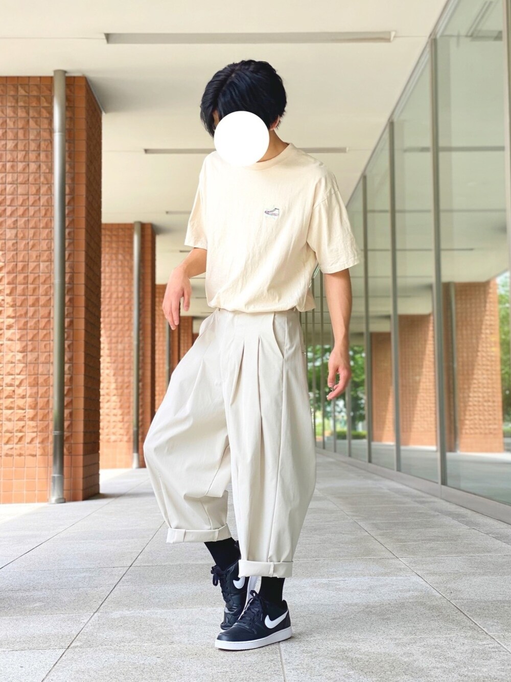 ベージュ系のTシャツ/カットソー、ホワイト系のその他パンツ、ブラック系のスニーカーを着用したメンズの夏コーディネートの1枚目の写真
