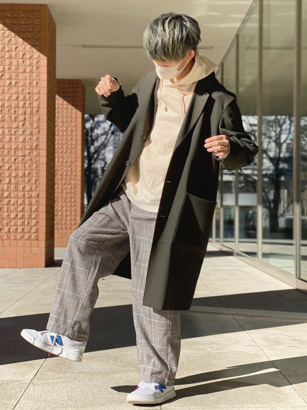 ベージュ系のTシャツ/カットソー、グリーン系のチェスターコート、ブラウン系のスラックスを着用したメンズの冬コーディネートの1枚目の写真