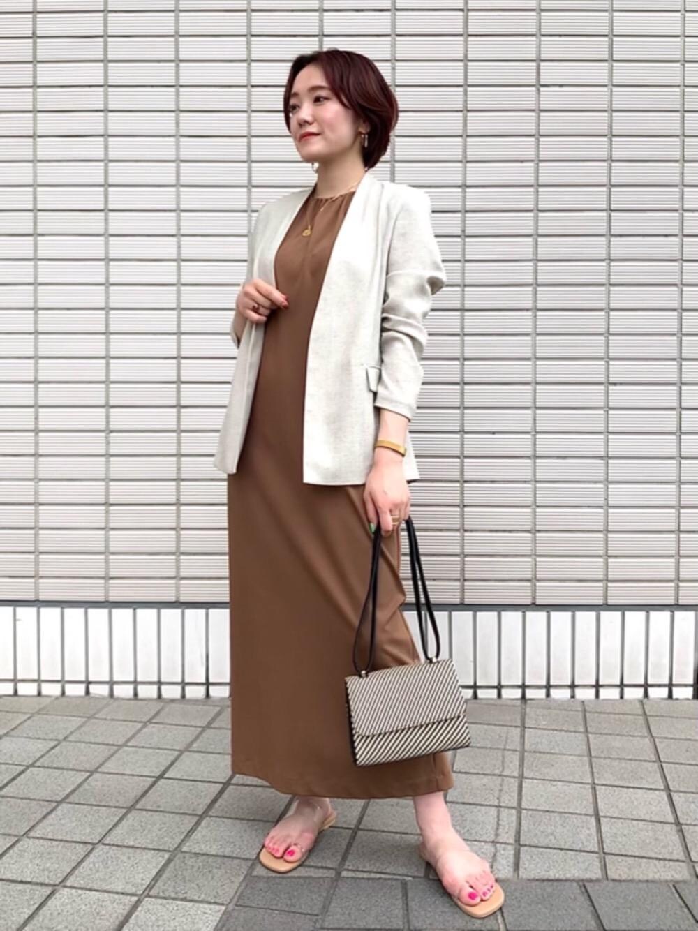 ベージュ系のサンダル、ベージュ系のノーカラージャケット、ブラック系のショルダーバッグを着用したレディースの夏コーディネートの1枚目の写真