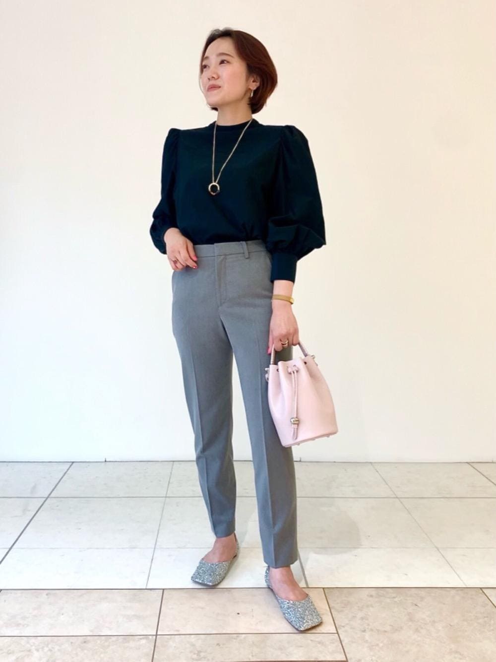 シルバー系のパンプス、グレー系のその他パンツ、ピンク系のショルダーバッグを着用したレディースの秋コーディネートの1枚目の写真