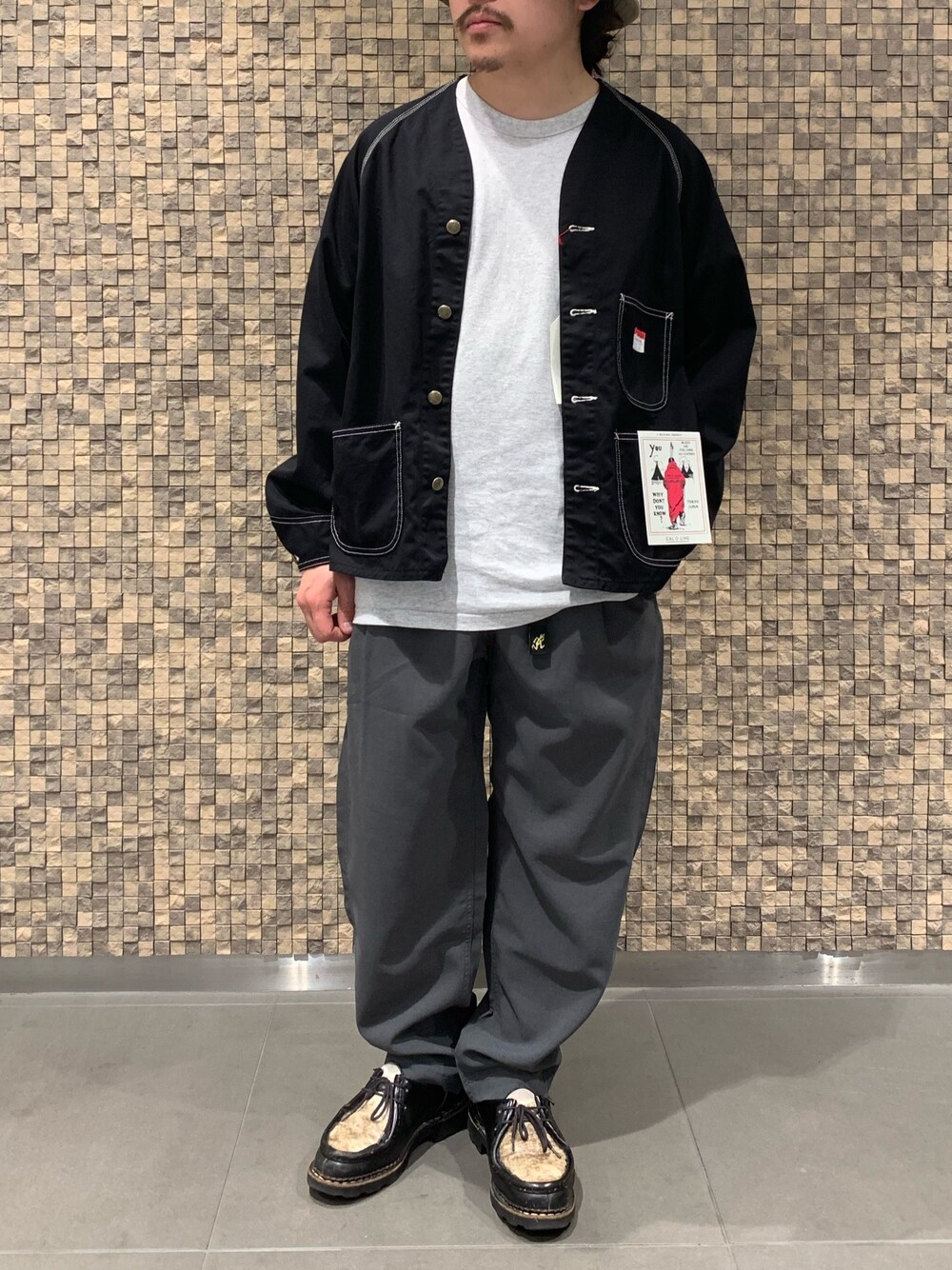 ブラック系のブルゾン、グレー系のスラックスを着用したメンズの春コーディネートの1枚目の写真