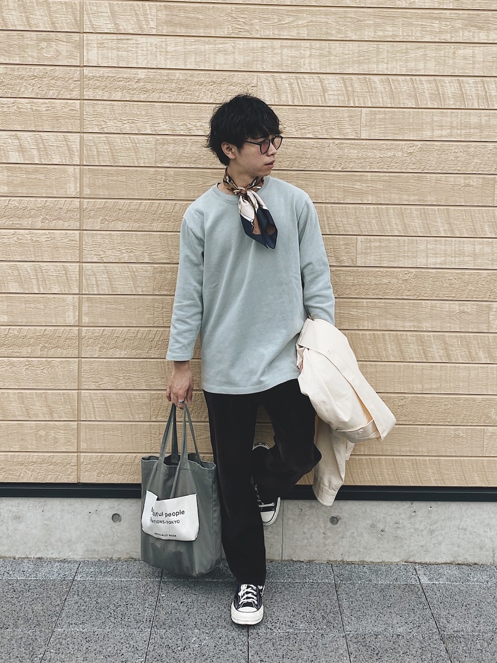 グリーン系のTシャツ/カットソー、グレー系のトートバッグ、ブラック系のスニーカーを着用したメンズの春コーディネートの1枚目の写真