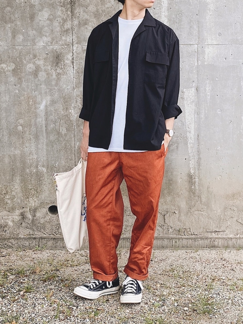 ベージュ系のパンツ、ベージュ系のトートバッグ、ブラック系のシャツ/ブラウスを着用したメンズの春コーディネートの1枚目の写真