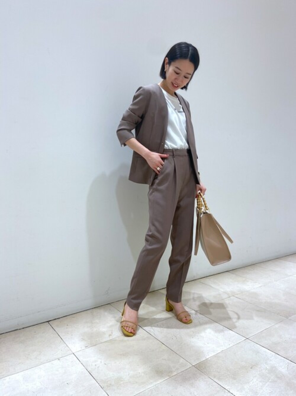 ブラウン系のノーカラージャケット、ブラウン系のその他パンツ、ホワイト系のTシャツ/カットソーを着用したレディースの夏コーディネートの1枚目の写真