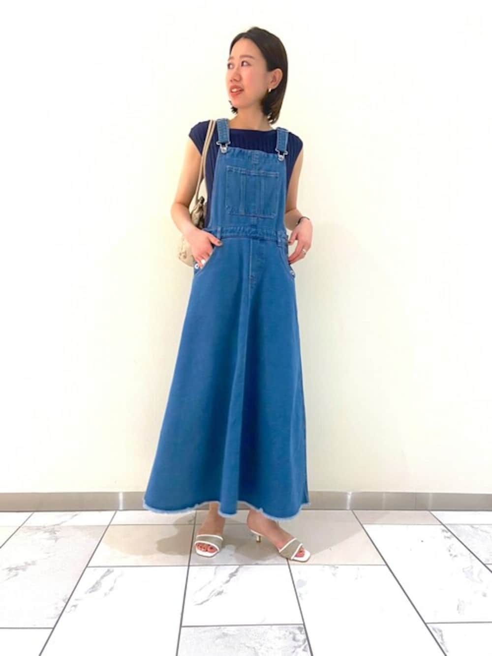 ブルー系のニット/セーター、ブルー系のワンピース、ベージュ系のショルダーバッグを着用したレディースの夏コーディネートの1枚目の写真