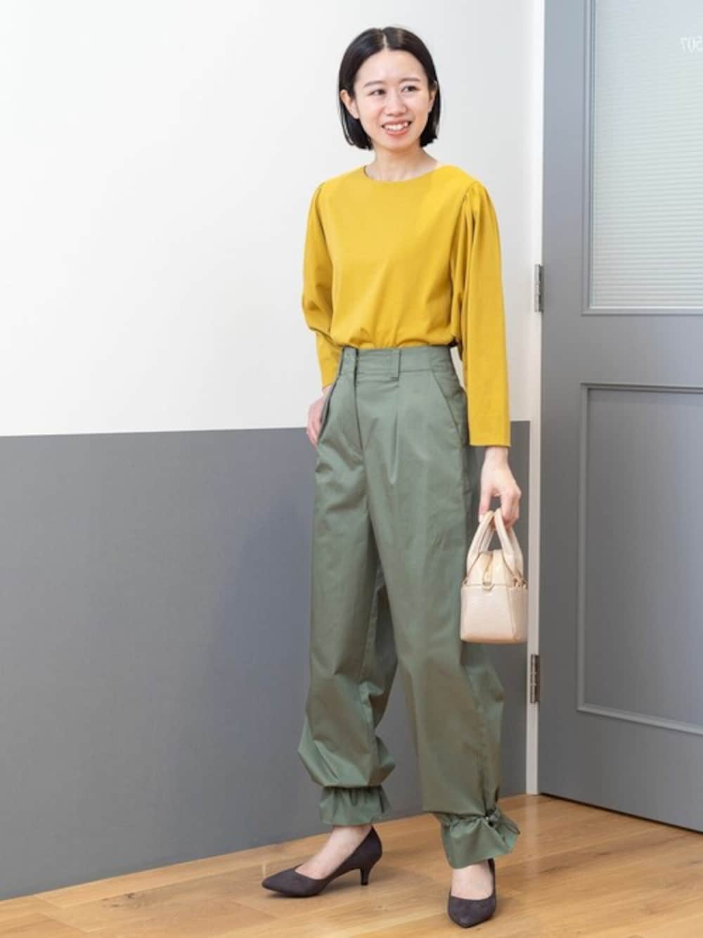 イエロー系のTシャツ/カットソー、グリーン系のその他パンツ、ベージュ系のショルダーバッグを着用したレディースの夏コーディネートの1枚目の写真