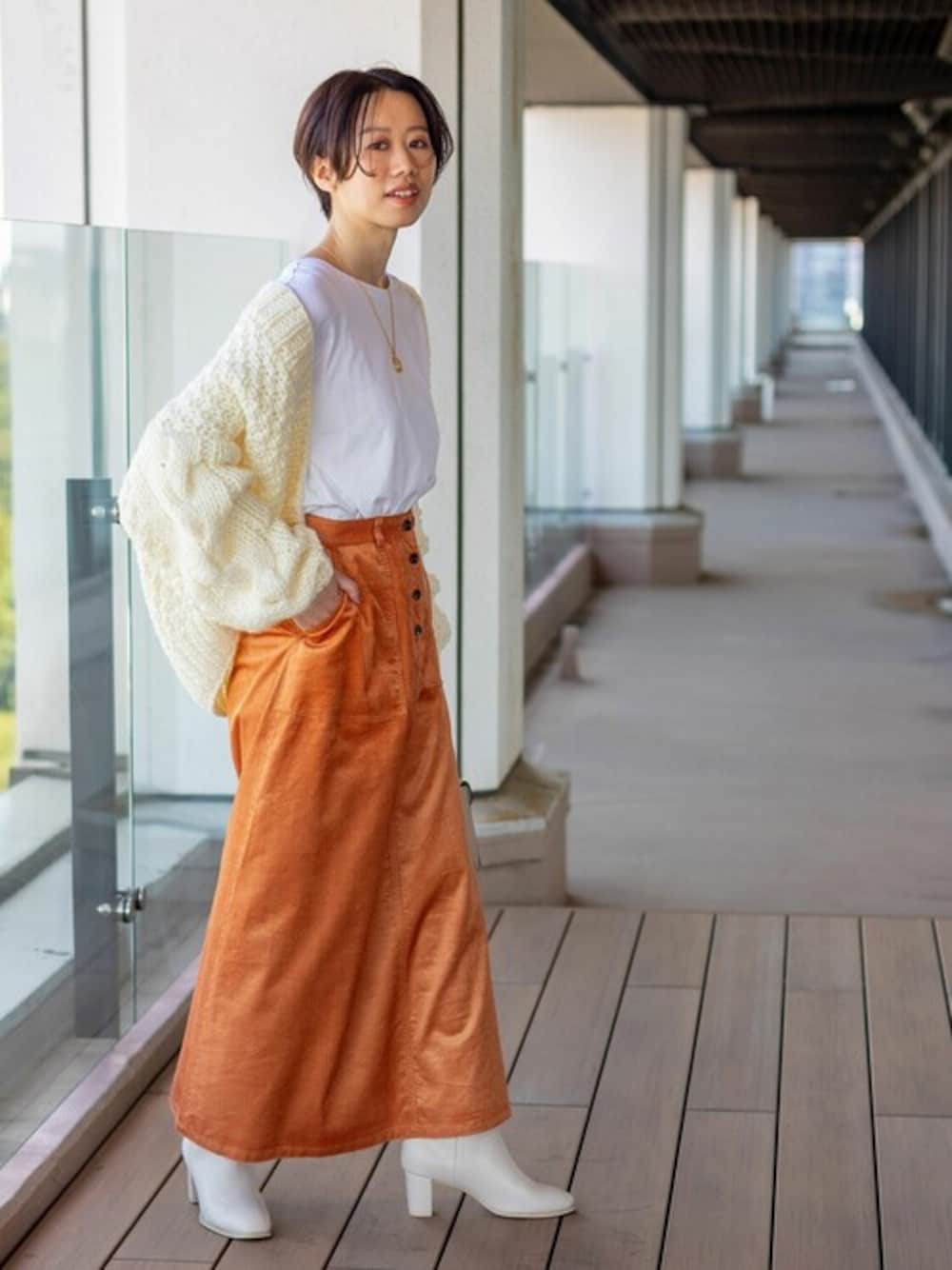 ホワイト系のTシャツ/カットソー、ホワイト系のカーディガン/ボレロ、オレンジ系のスカートを着用したレディースの秋コーディネートの1枚目の写真