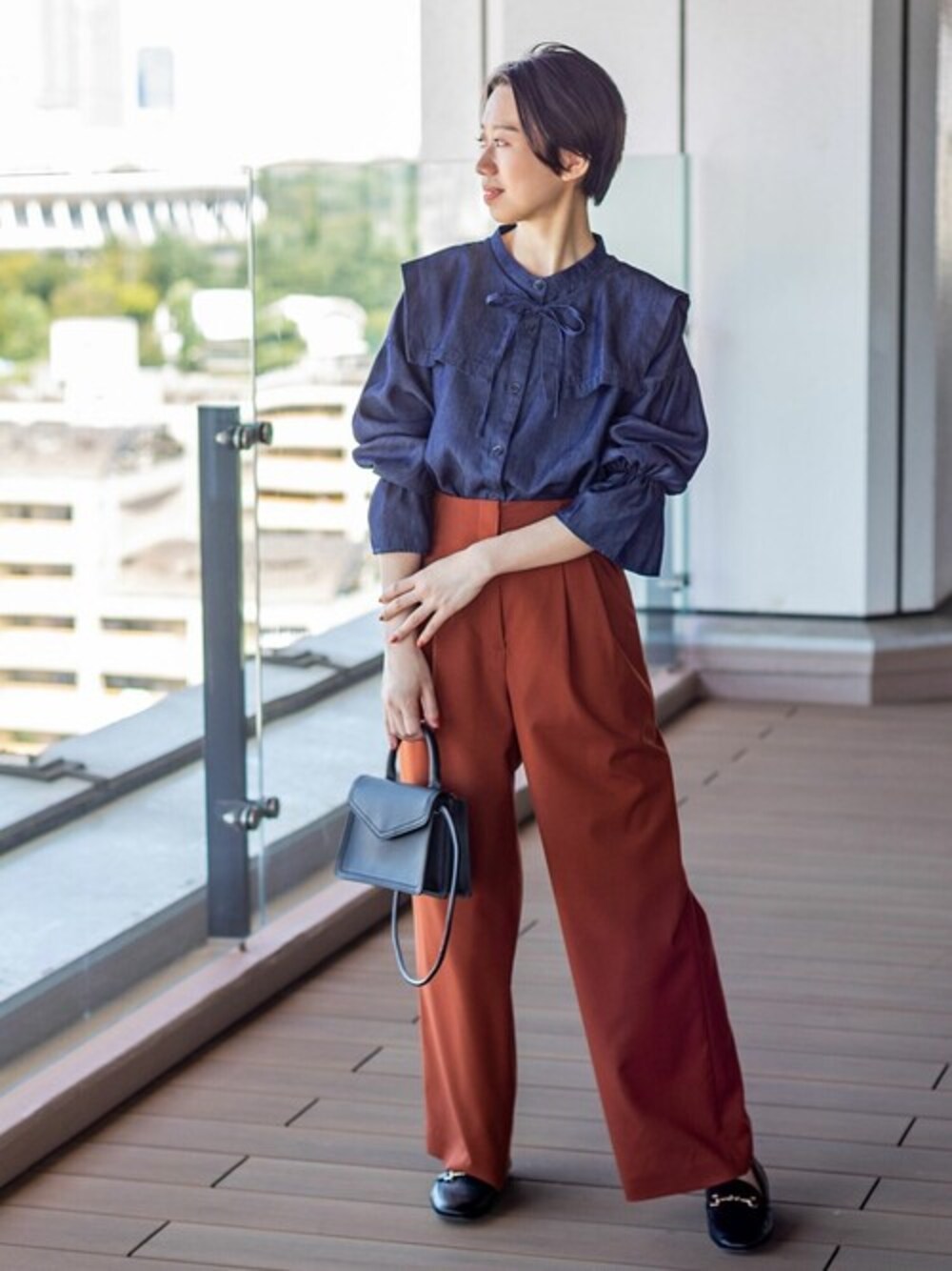 ブルー系のシャツ/ブラウス、ブラウン系のその他パンツ、ブラック系のショルダーバッグを着用したレディースの秋コーディネートの1枚目の写真