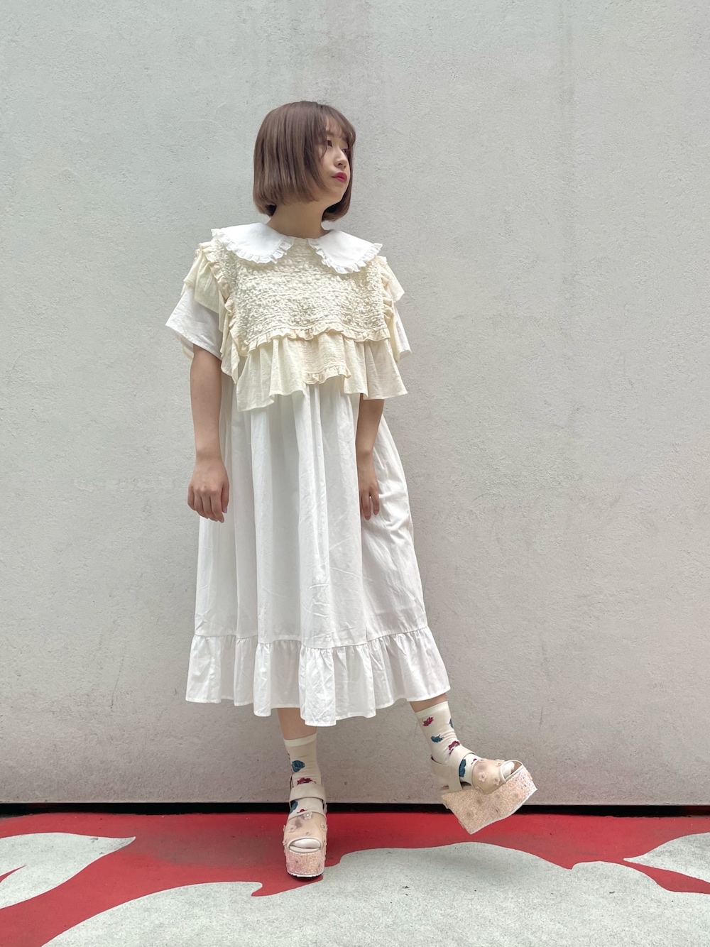 ホワイト系のワンピース、ピンク系のサンダル、ホワイト系の付け襟を着用したレディースの春コーディネートの1枚目の写真