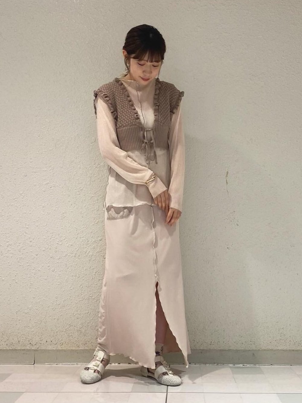 ベージュ系のニット/セーター、ホワイト系のチュニック、ベージュ系のスカートを着用したレディースの夏コーディネートの1枚目の写真